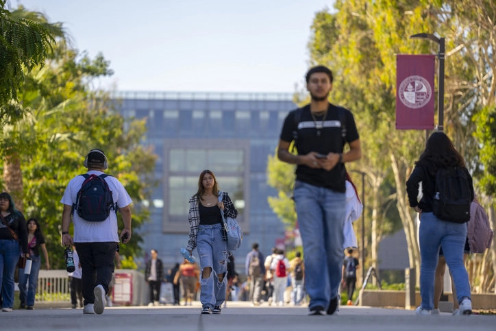 College students walk across campus on a sunny day