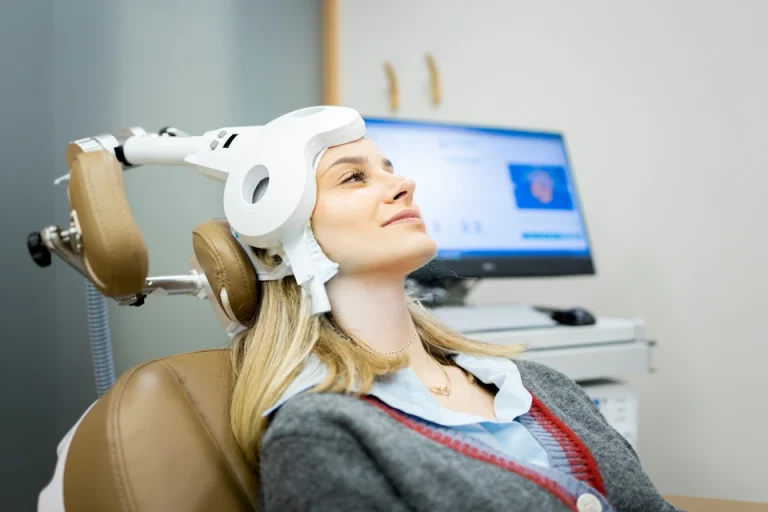 A woman smiles while she receives TMS therapy